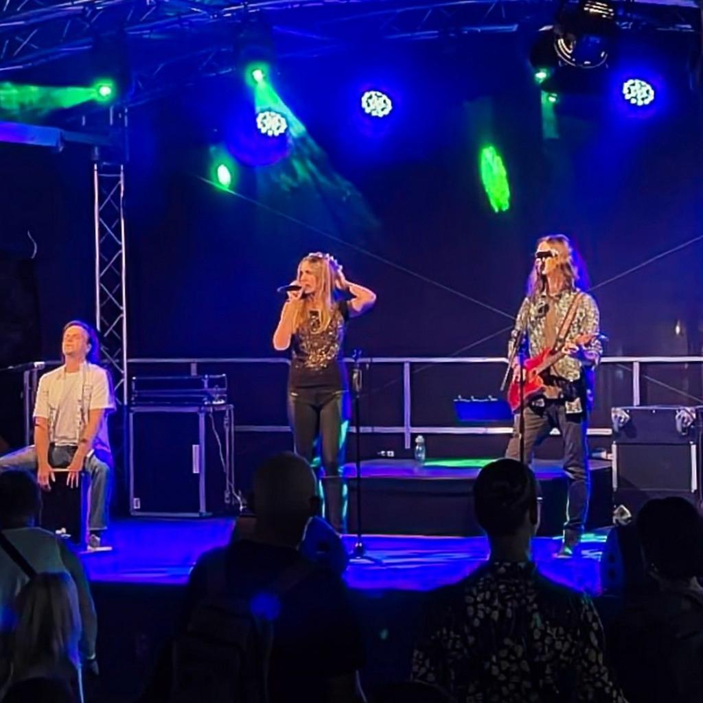 Die drei Musiker von JustBrill!-unplugged auf einer Bühne in blauem Licht